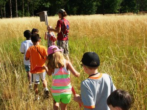 Examining a Bluebird Nest Box in a prarie with a group of children