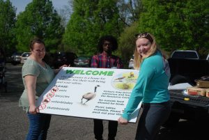 Sanctuary staff holding new welcome sign