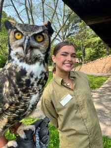 Ada Varga standing next to a Great-horned Owl 