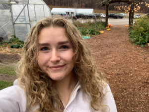 Image of Kelly Baltusis with greenhouse background and natural trail