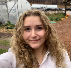 Image of Kelly Baltusis with greenhouse background and natural trail