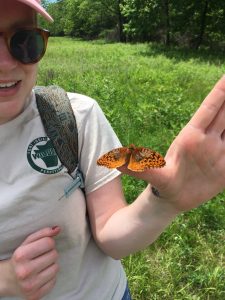 Image of Alice Dykstra holding a fritillary butterfly