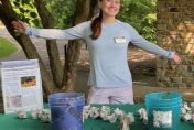 Madison Aprill standing with outstretched arms at Wild Wednesday table
