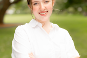 Bella Oliva standing with arms crossed smiling at camera