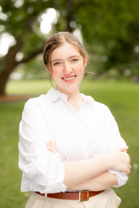 Bella Oliva standing with arms crossed smiling at camera