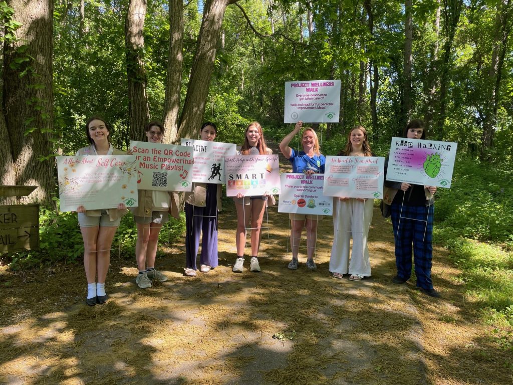 Girl Scouts holding up the signs they made about wellness